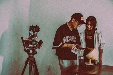 Two crew members checking a monitor beside the camera