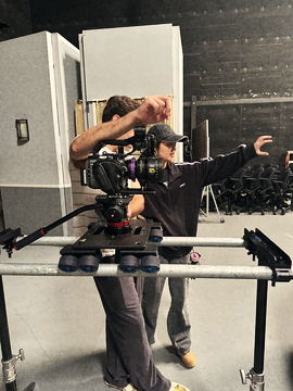 Camera operator rehearsing a move on the slider