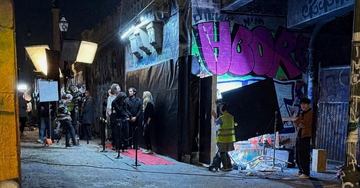 A graffiti alley set at night with the crew at work